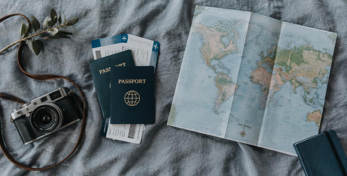 Passaportes, cartões de embarque e mapa-múndi sobre tecido cinza